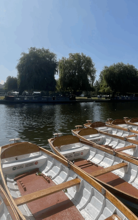 Empty rowing boats along the River Avon with a clear blue sky
