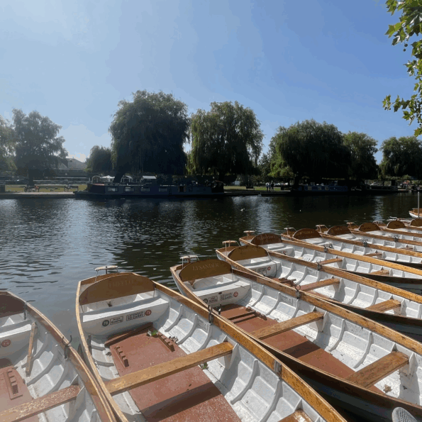 Empty rowing boats along the River Avon with a clear blue sky
