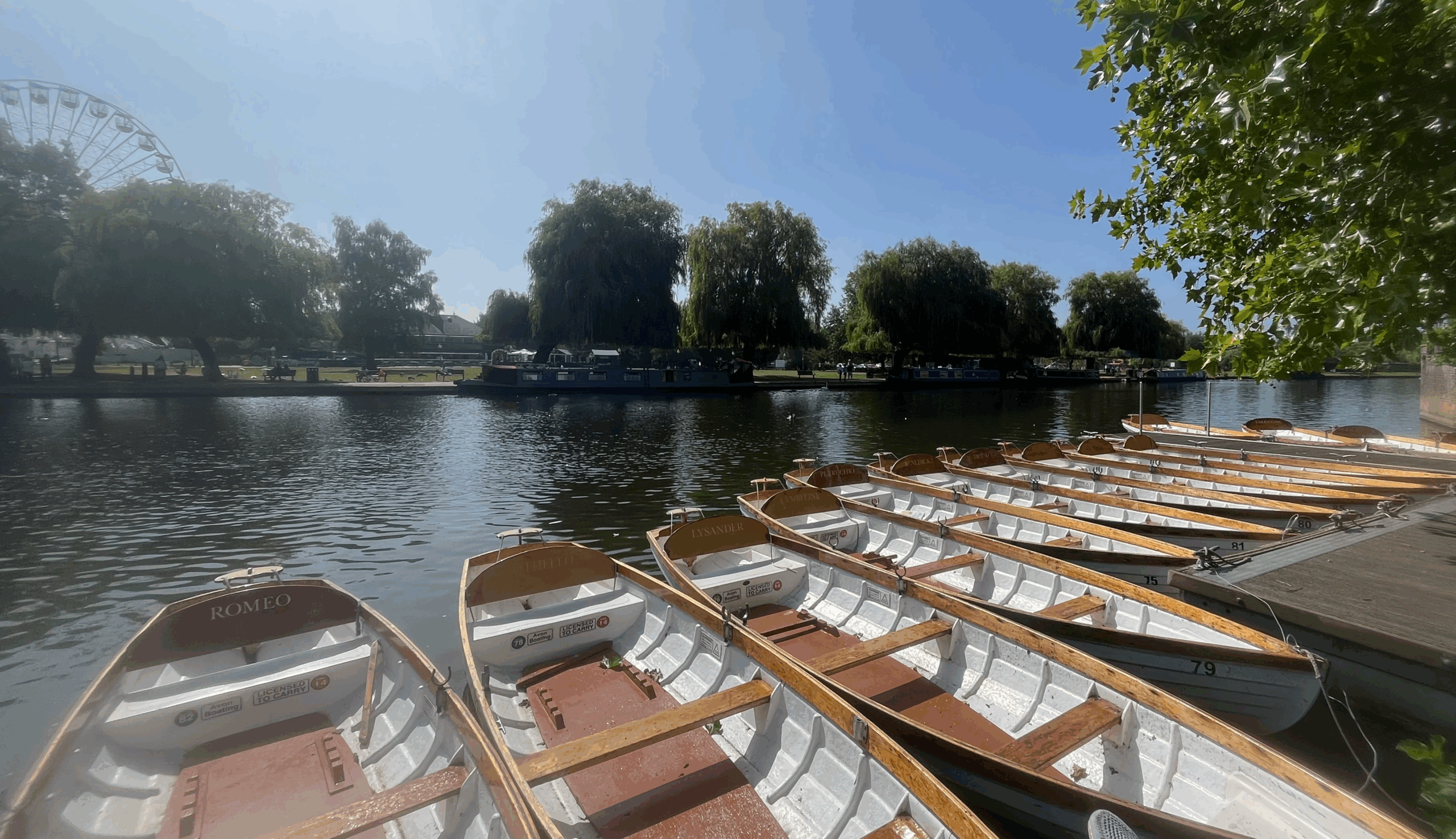 Empty rowing boats along the River Avon with a clear blue sky
