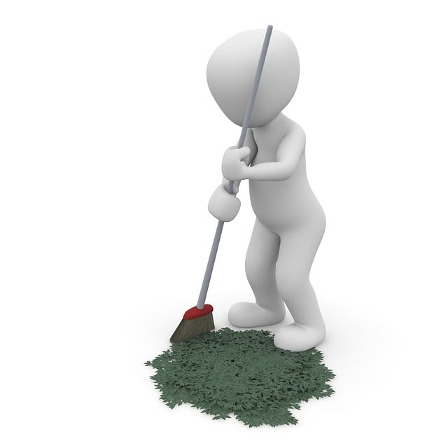Human figure sweeping leaves with a broomstick